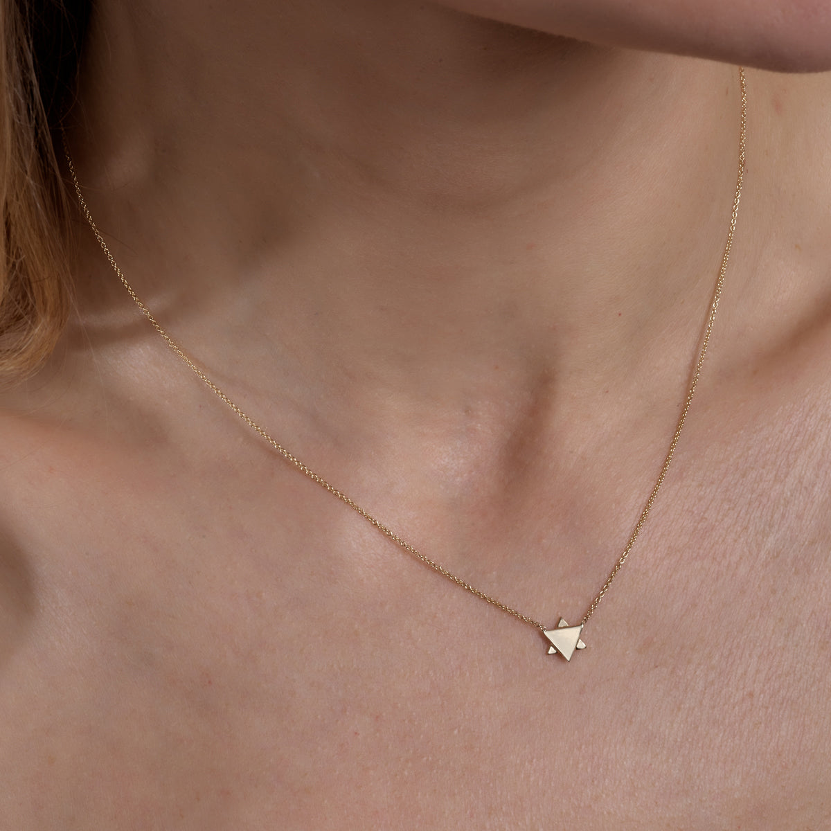 Model wearing Star of David necklace in gold from Phoenix Roze, delicate Jewish pendant layered with everyday style.
