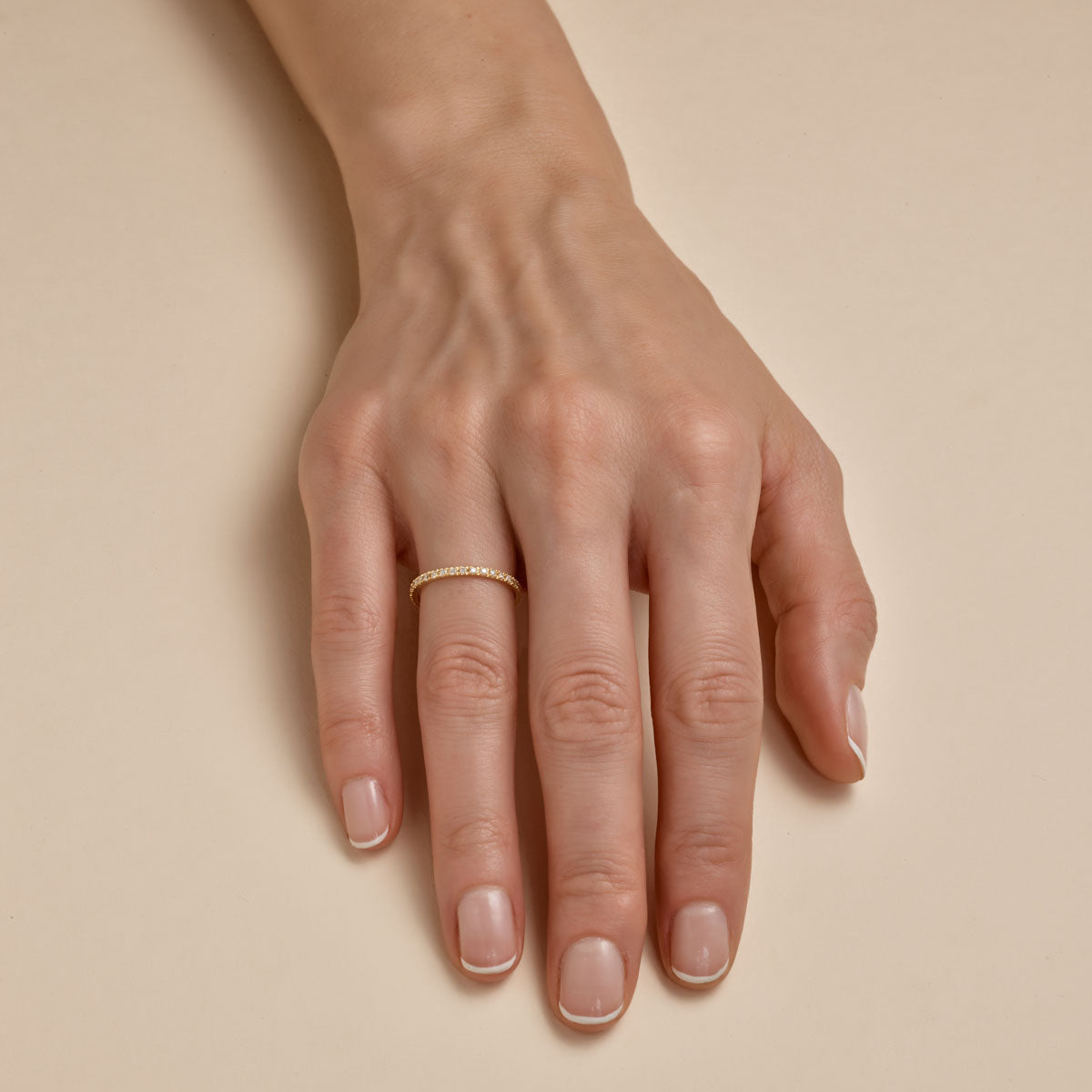Delicate 1pt diamond eternity band on a woman's finger, thin ring with sparkling pave diamonds by Phoenix Roze