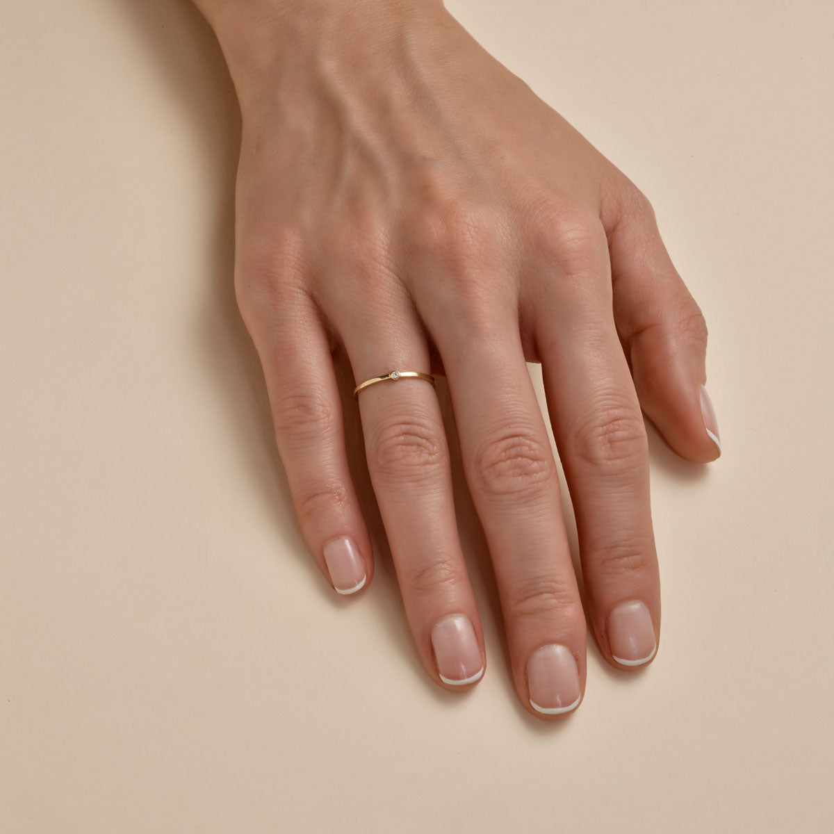 2mm gold wedding band on woman's finger, delicate yellow gold ring, minimalist bridal jewelry by Phoenix Roze