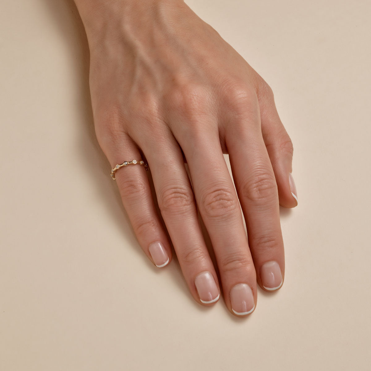 Sparkling diamond and gold infinity halo band ring on woman's finger