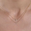 Elevate your style with 14k gold initial and Taurus necklaces adorning a woman's neck.