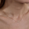 Dainty gold NYC pendant necklace on a woman's neck by Phoenix Roze, city-chic jewelry