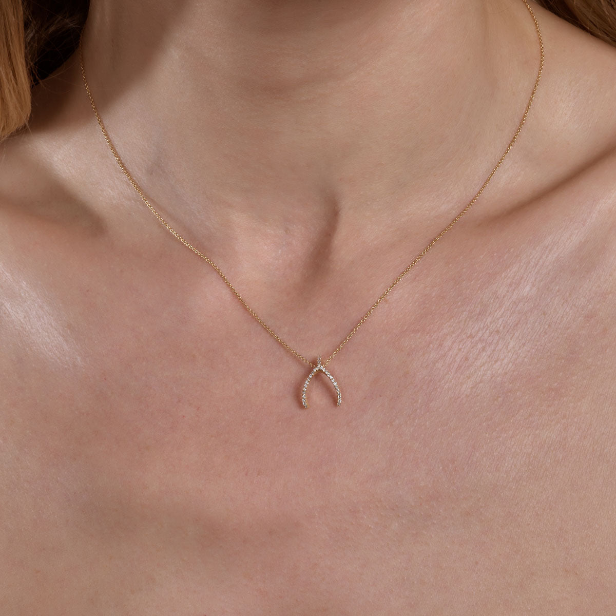 gold diamond wishbone necklace on neck