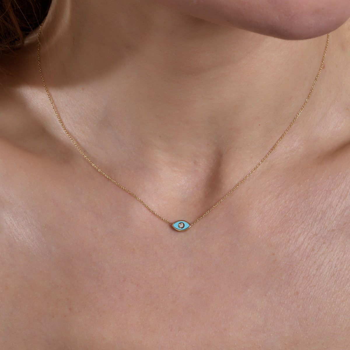 Gold turquoise evil eye necklace on model's neck, delicate protective charm pendant by Phoenix Roze