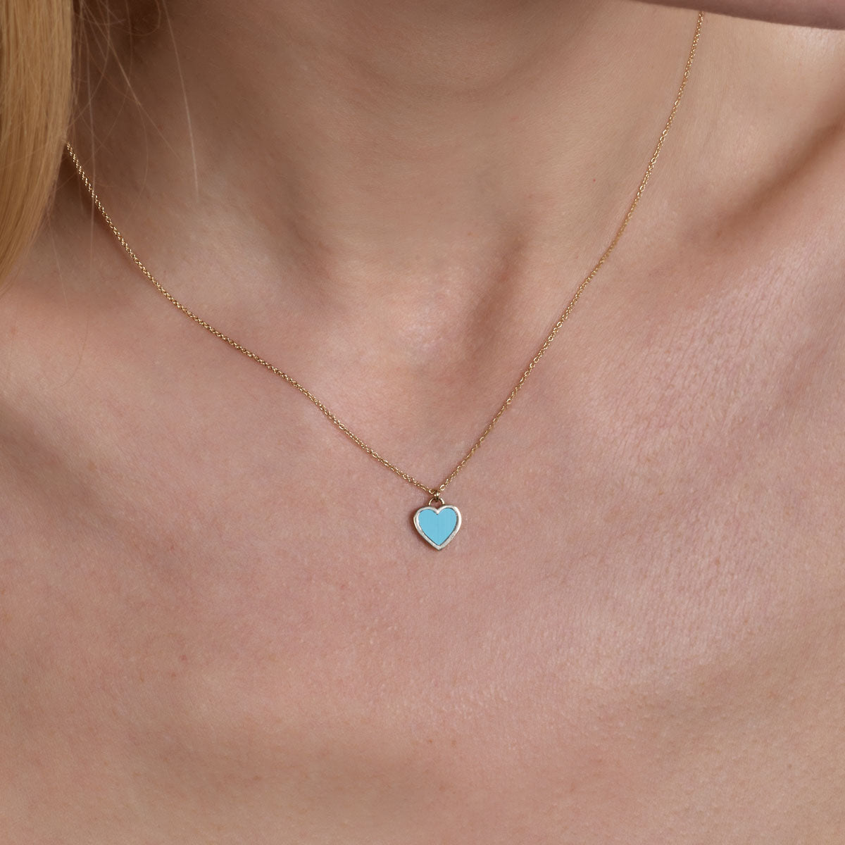 Gold turquoise large heart necklace on model’s neck by Phoenix Roze