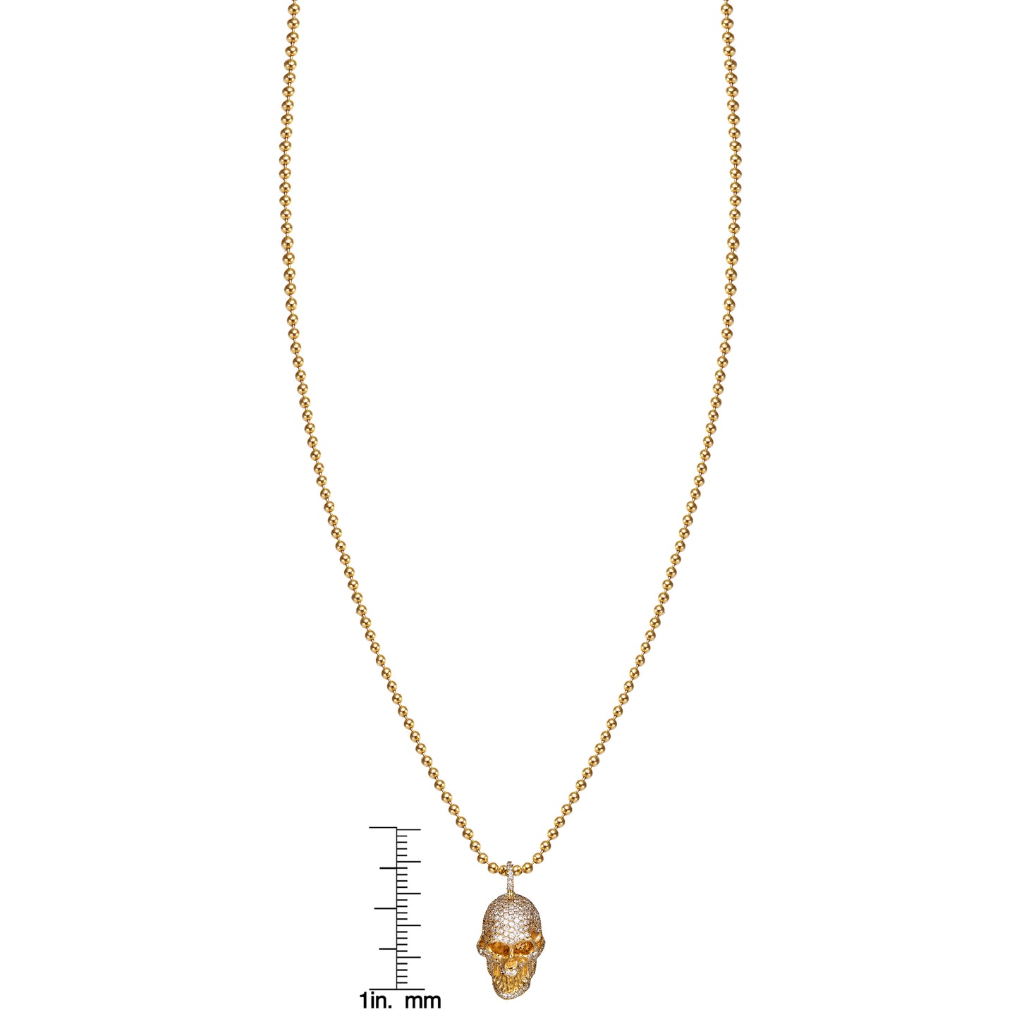Large diamond skull gold necklace by Phoenix Roze next to ruler for scale, edgy luxury pendant
