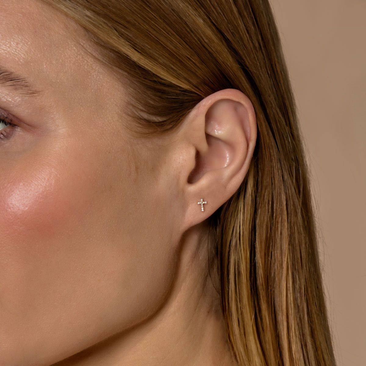 Model wearing tiny diamond cross earrings, a delicate sparkle from Phoenix Roze