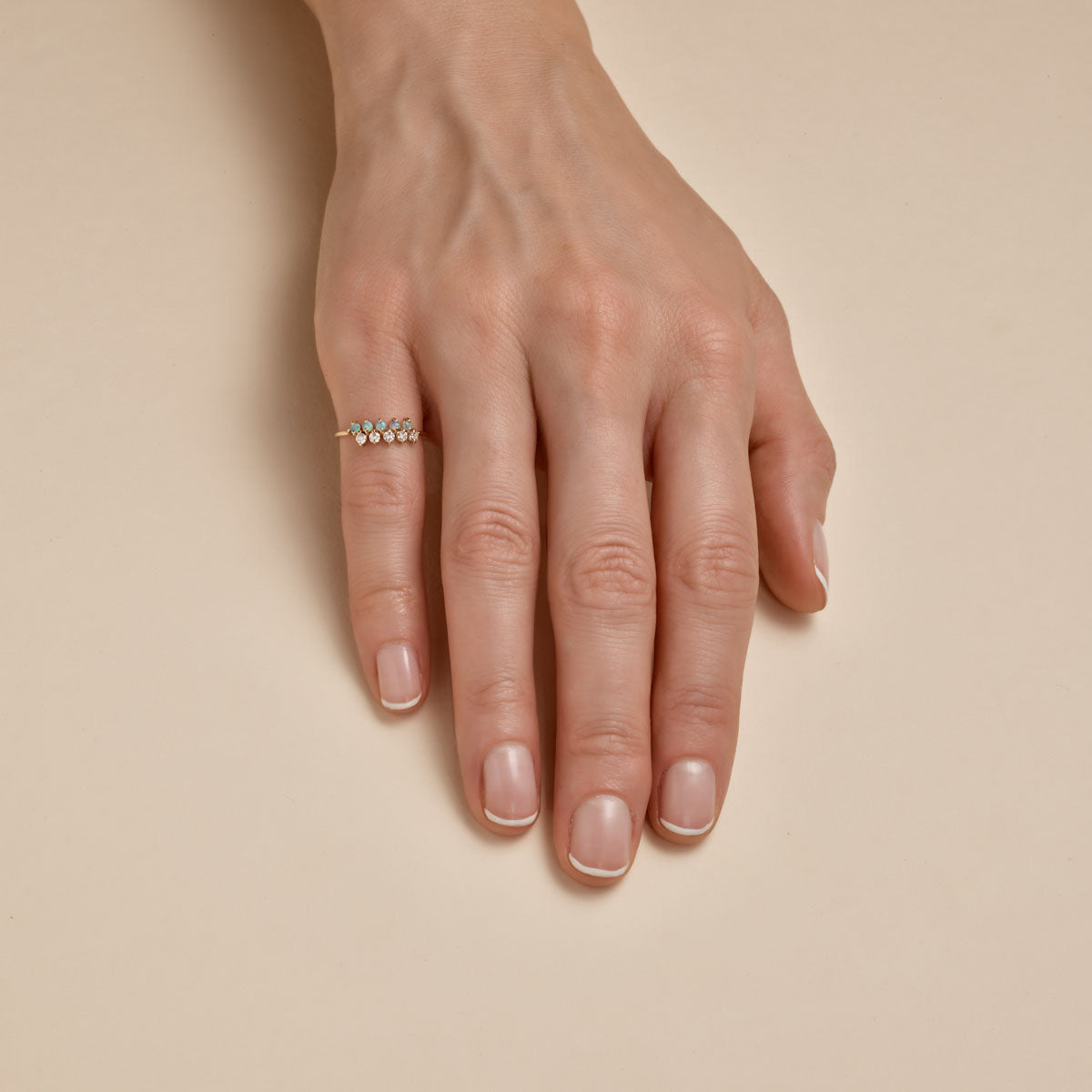 prong set opal and diamond ring on womans finger