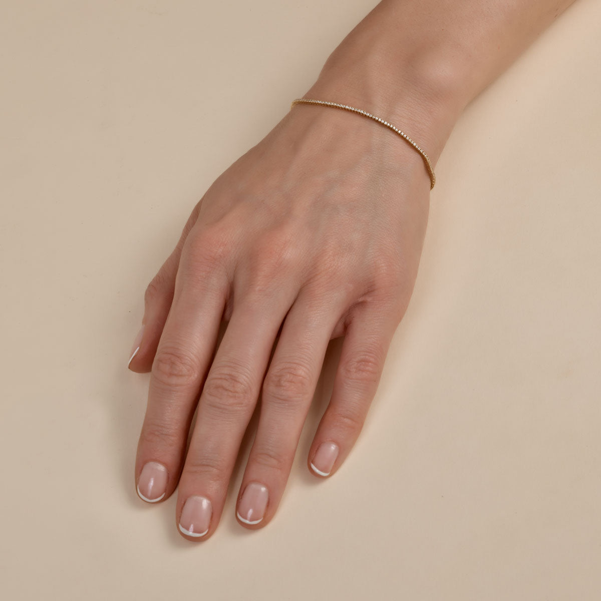 White diamond tennis bracelet on woman's hand, sparkling elegant fine jewelry from Phoenix Roze.