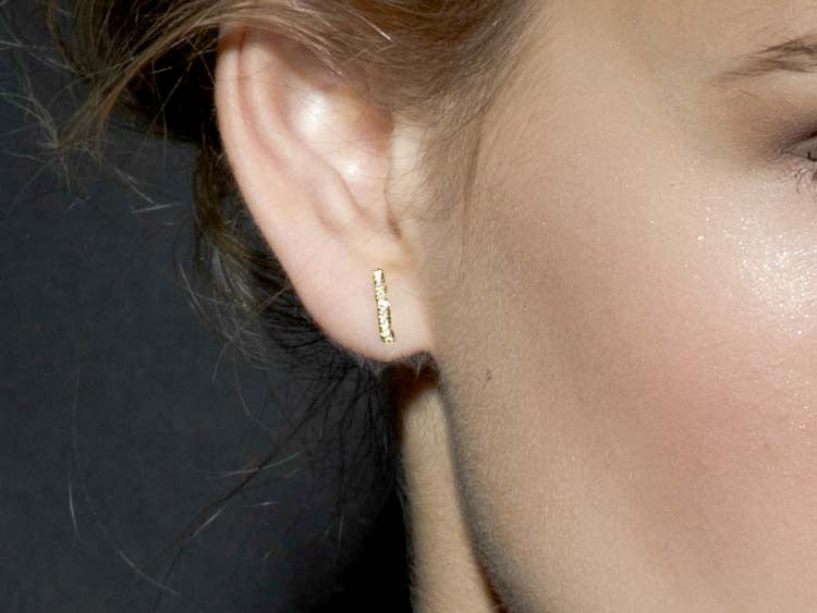 Woman wearing staple stud earrings.