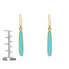Turquoise drop earring shown next to a ruler for size reference