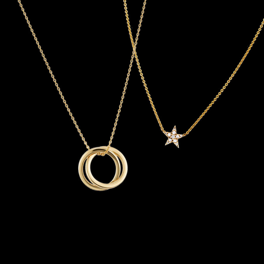 Two 14k gold necklaces layered together — an interlocking circle pendant and a diamond star pendant