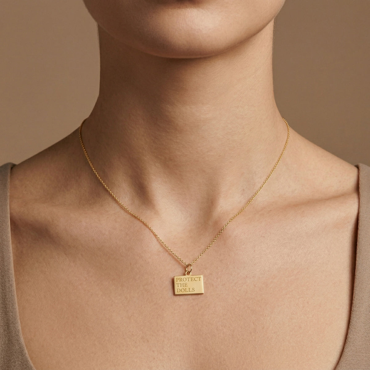 Protect the Dolls 14k gold pendant necklace worn on model at collarbone length