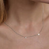 A minimalist silver chain necklace featuring two spaced-out initial charms, the letters V and H.
