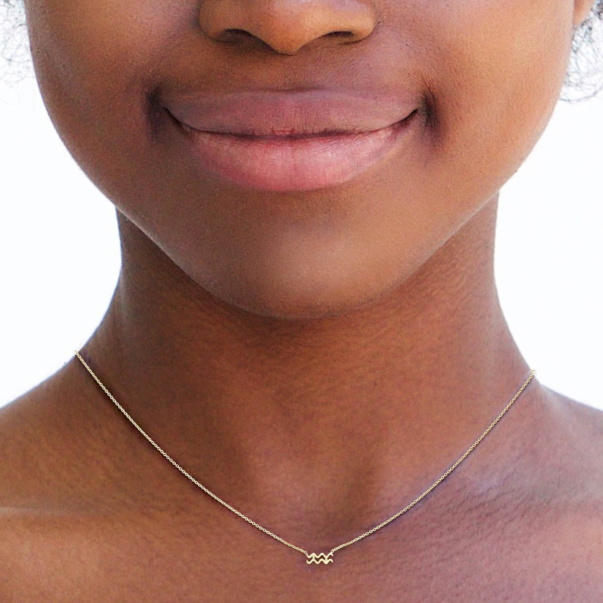 aquarius gold zodiac necklace on womans neck