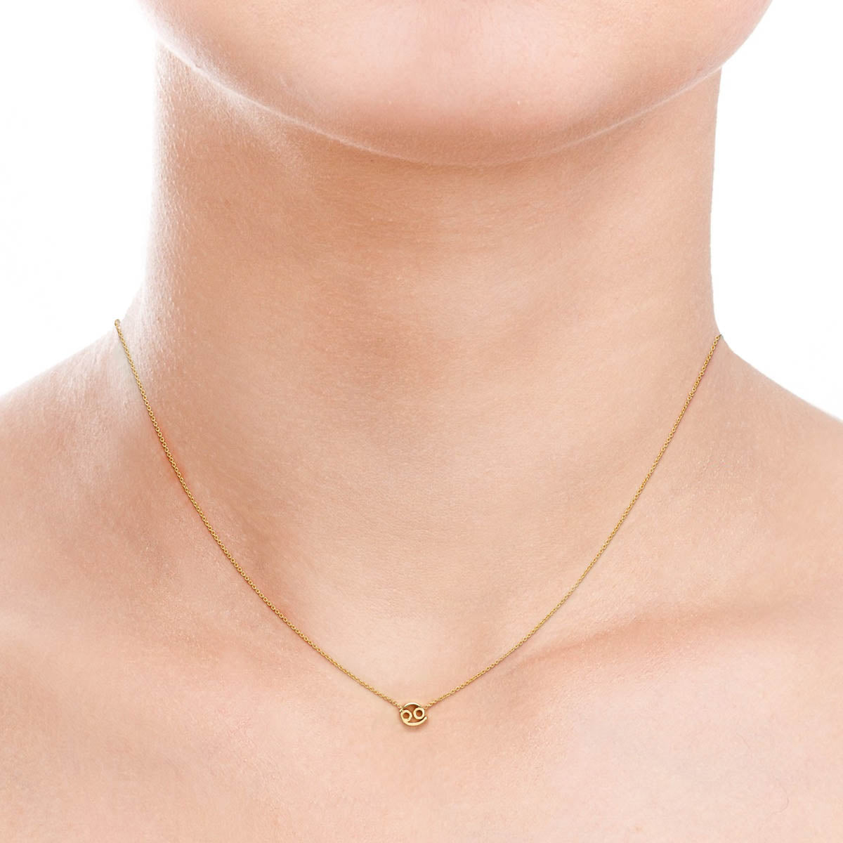 cancer gold zodiac necklace on womans neck