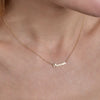 cursive handwritten word gold name necklace on womans neck