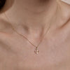gold anchor necklace on womans neck