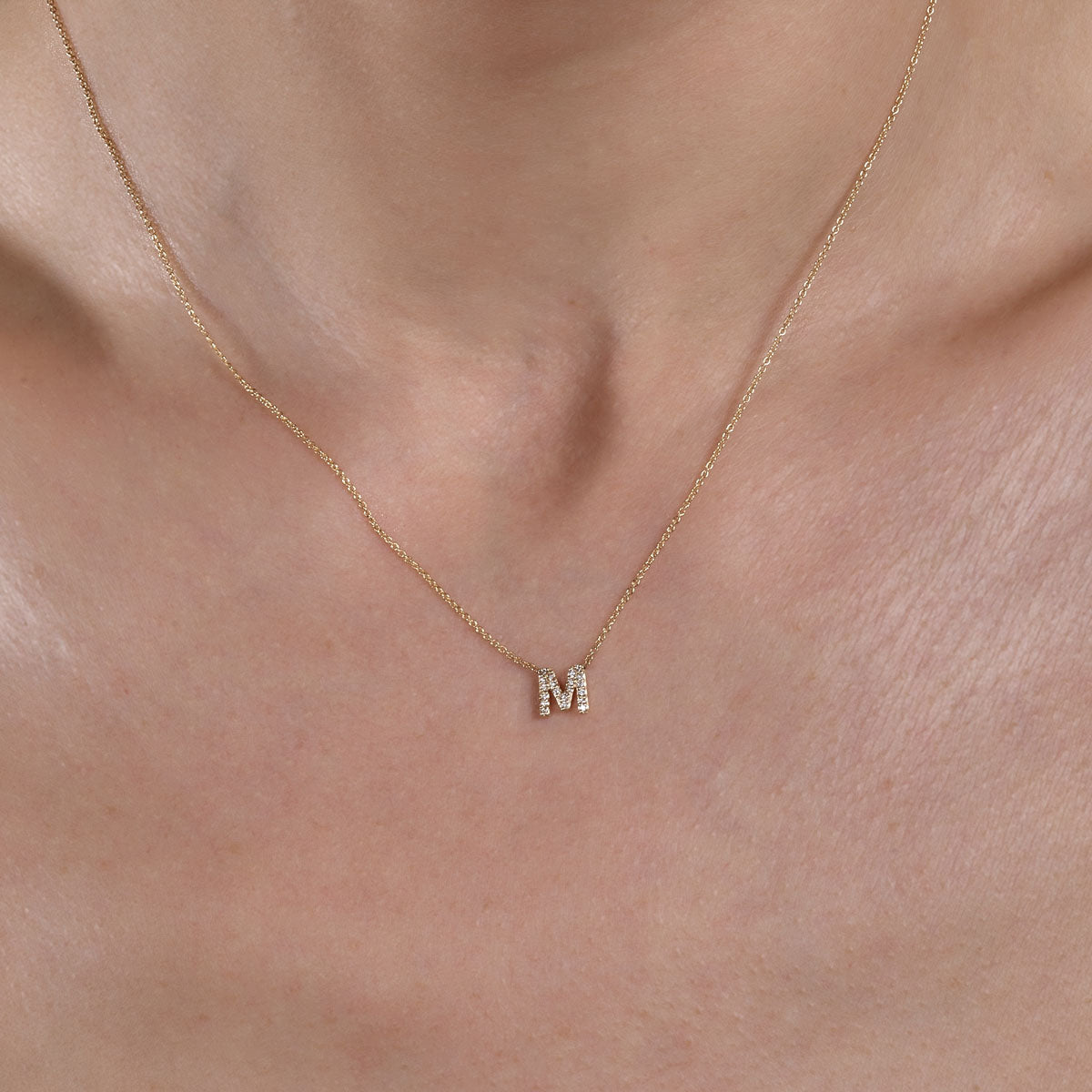 Model wearing gold diamond initial necklace, adding sparkle and personal style.