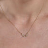 gold diamond angel wings necklace on neck