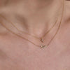 gold diamond cross necklace and gold NYC necklace on neck
