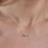 gold diamond cursive love necklace on womans neck