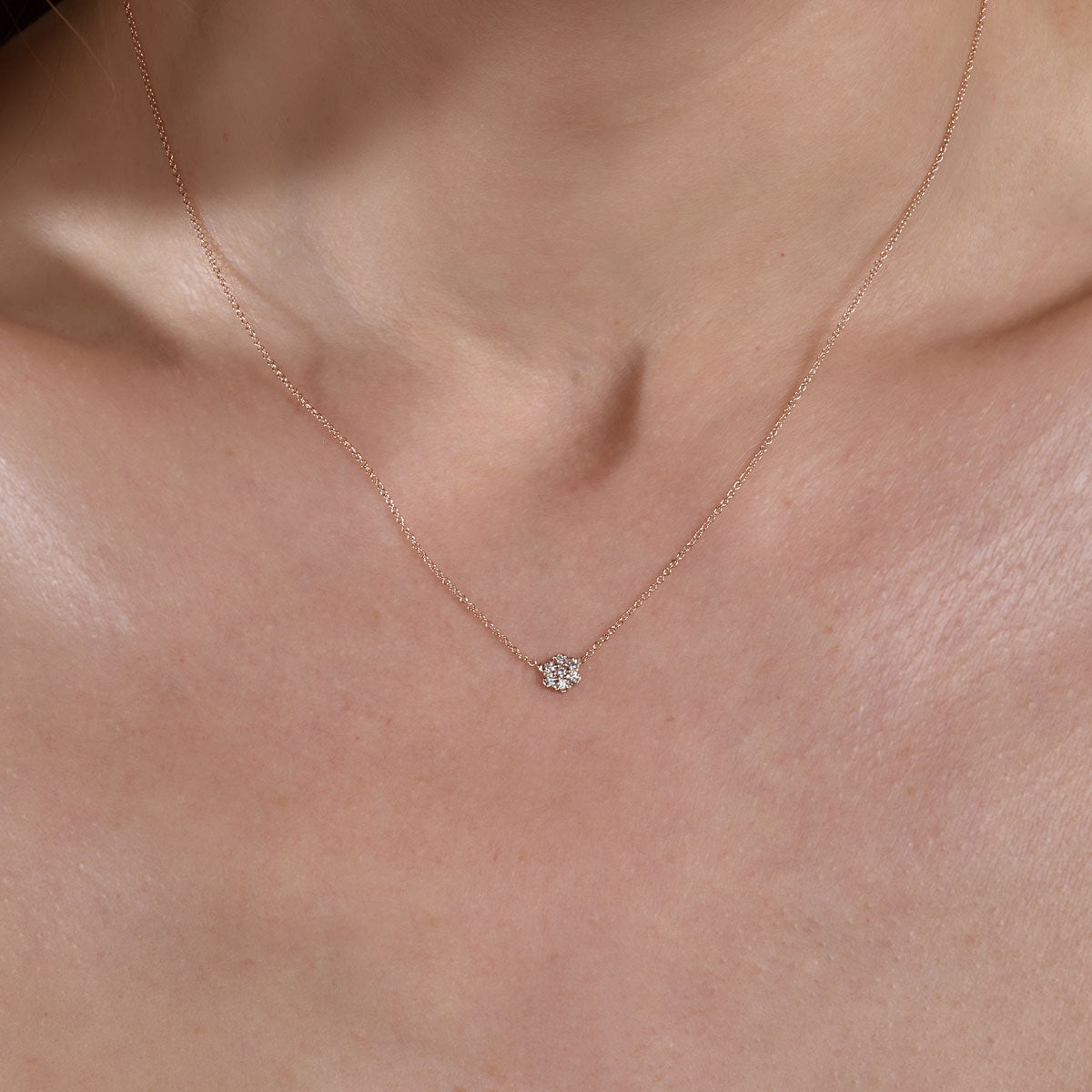 gold diamond flower necklace on neck