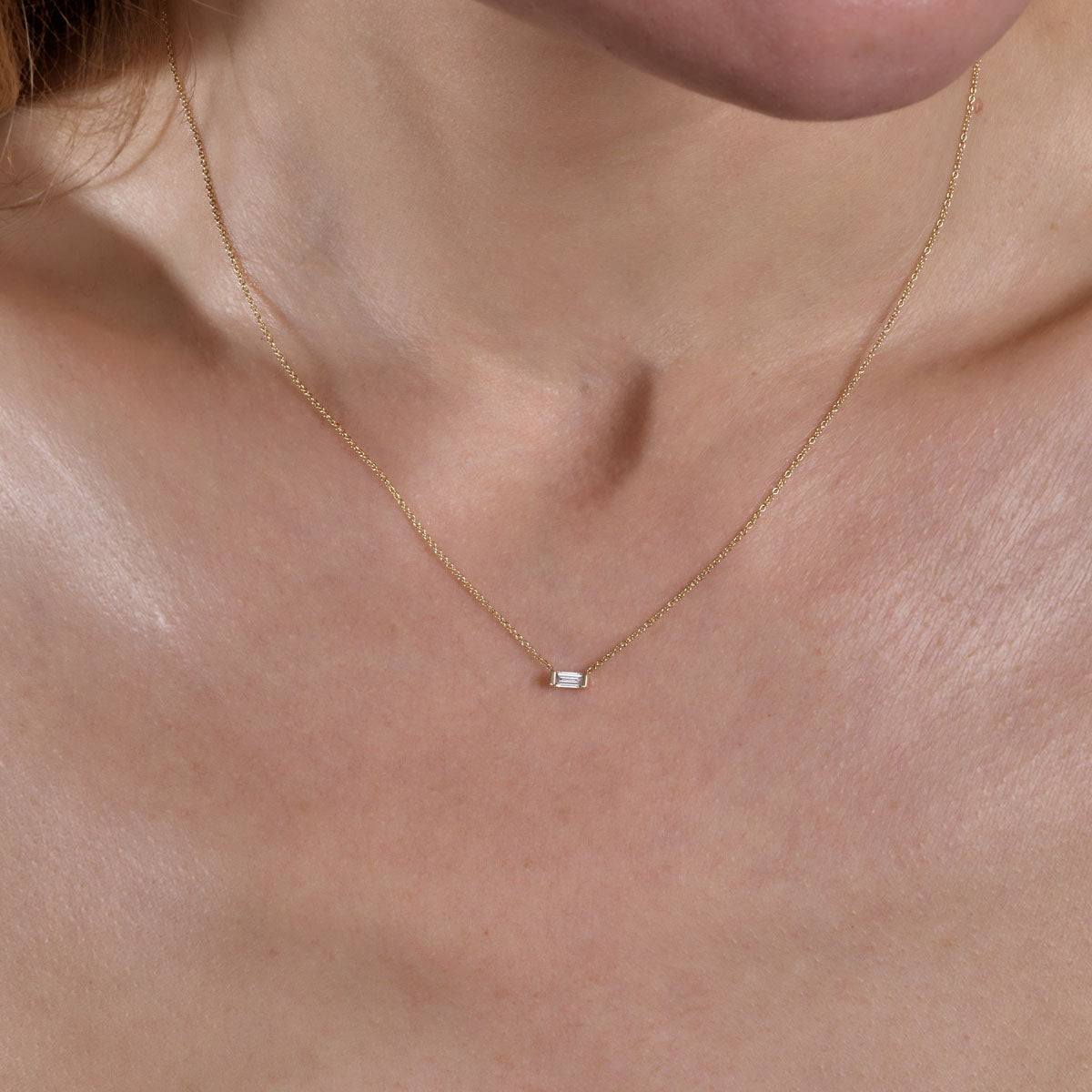 gold diamond rectangle necklace on neck