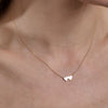 gold double heart necklace on womans neck