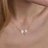 gold dragonfly necklace on models neck