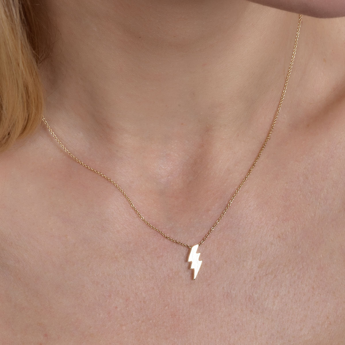 gold lightning necklace on womans neck