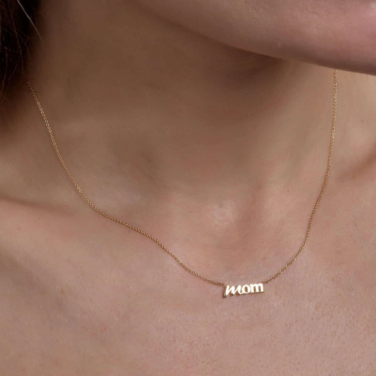 gold mom necklace on womans neck