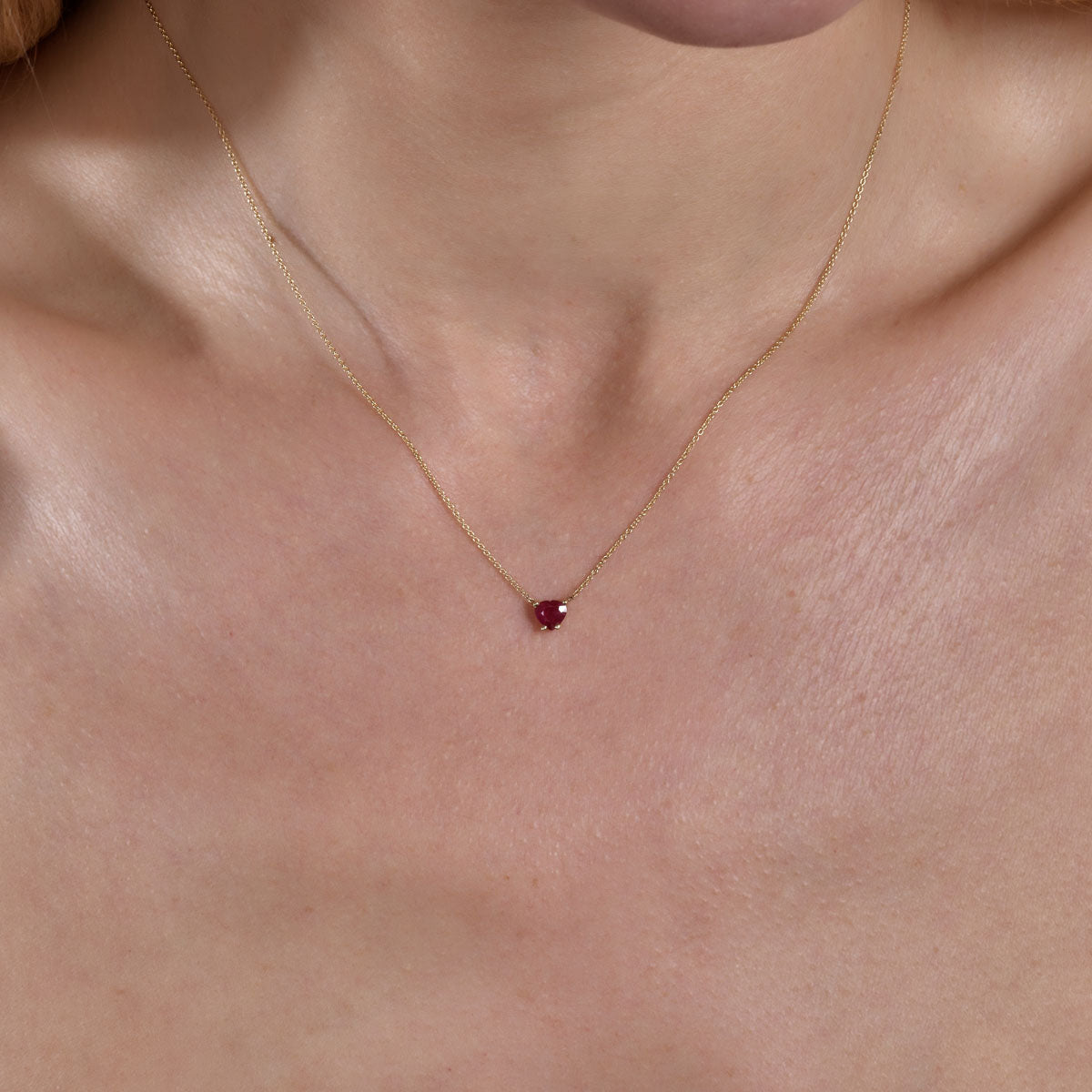 gold ruby heart necklace on neck