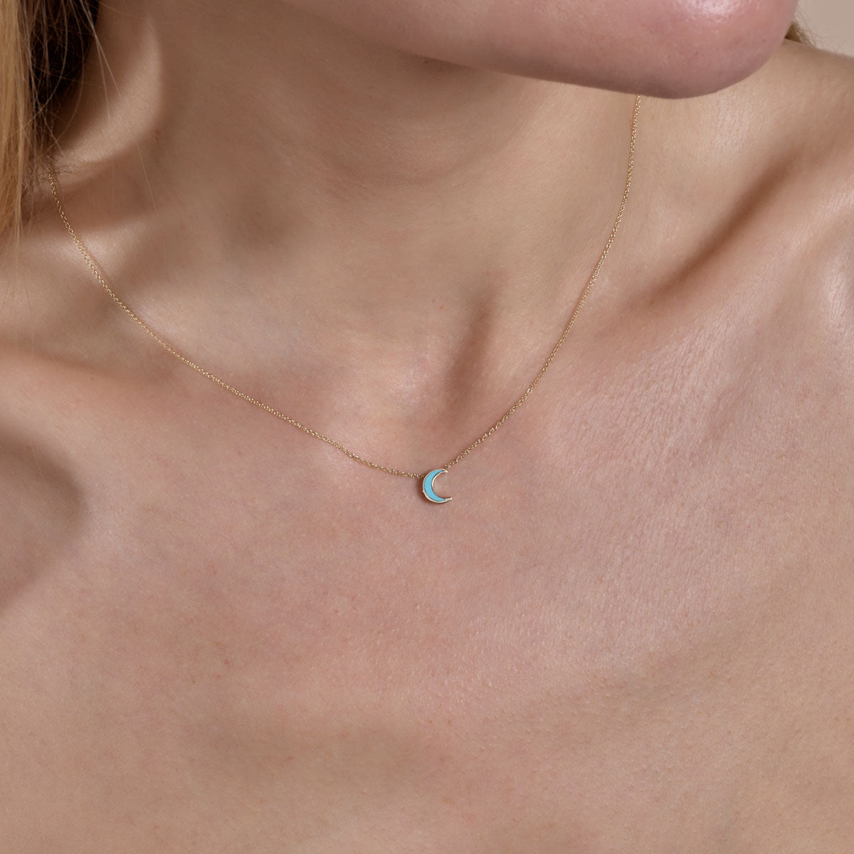 gold turquoise moon necklace on models neck