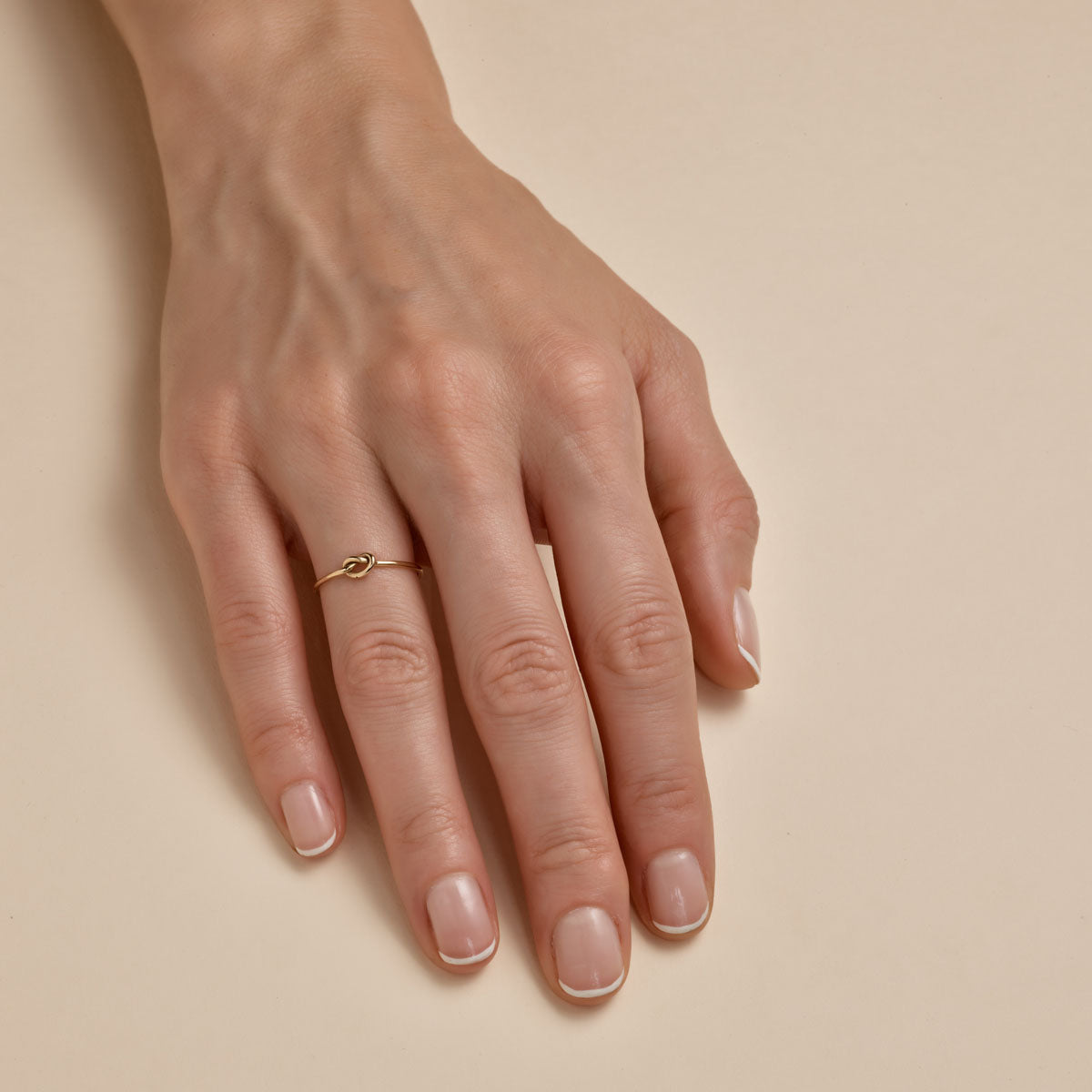 Lovers knot gold ring - romantic symbolic jewelry on woman's finger