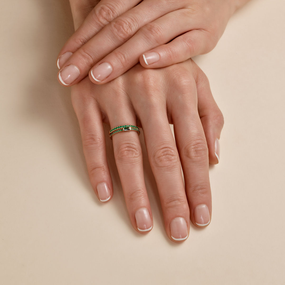 multiple emerald baguette ring on womans finger