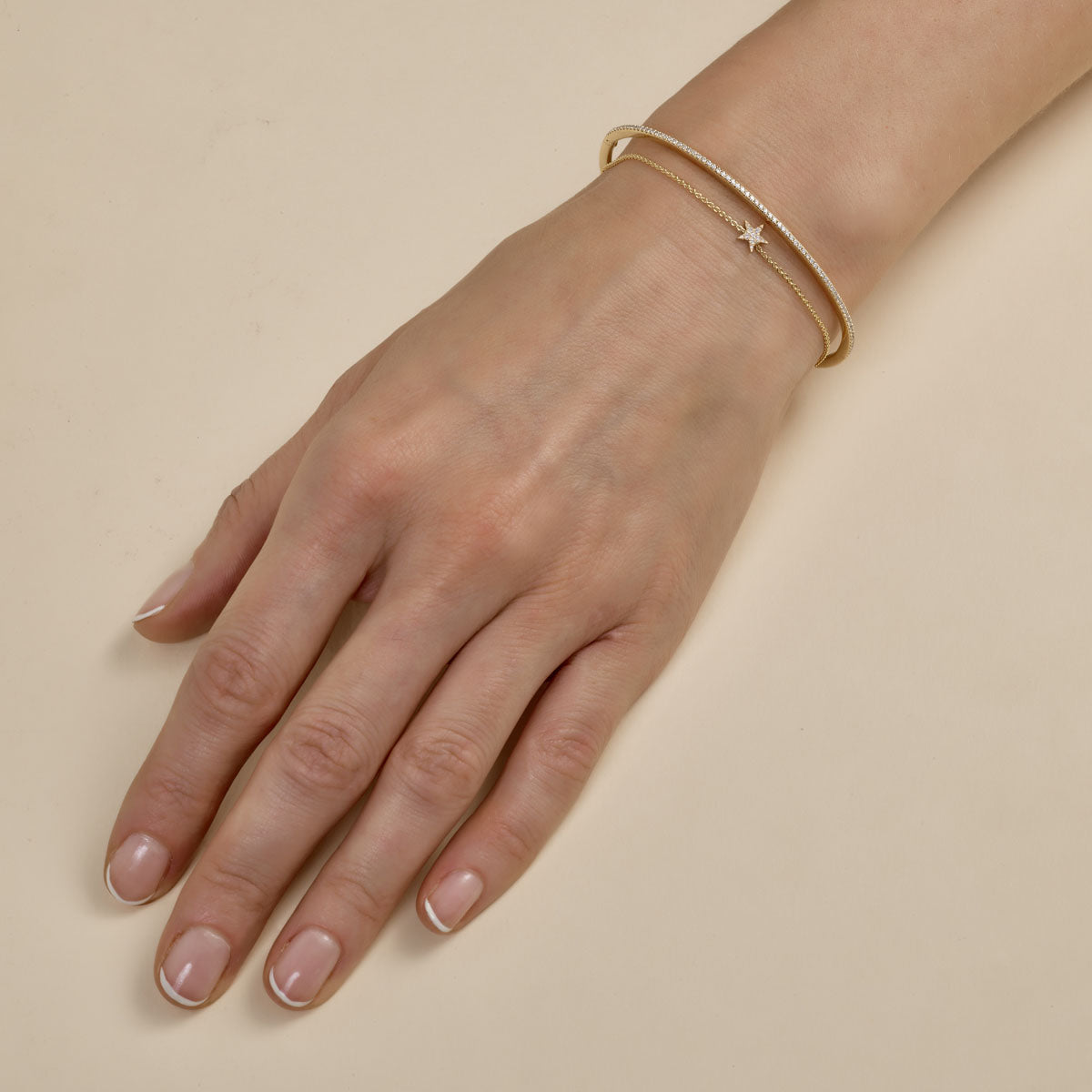 multiple gold bracelets stacked on womans hand