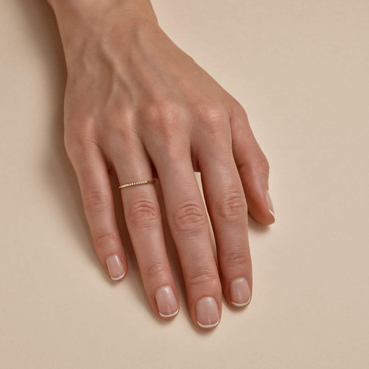 seven diamond gold band on womans finger