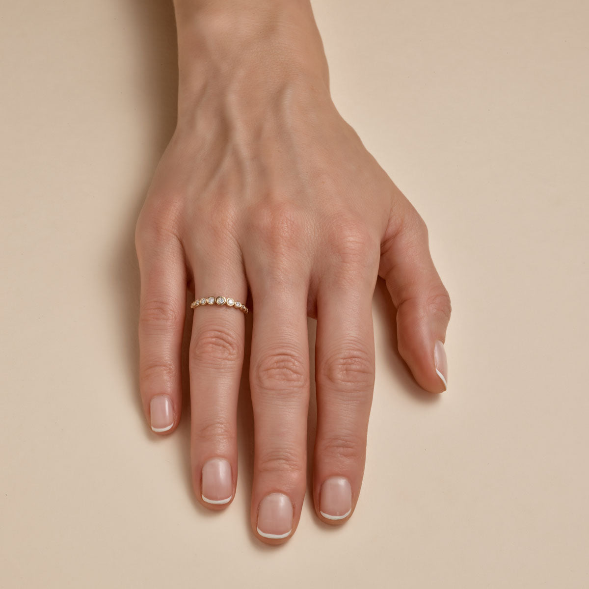tapered bezel gold ring on womans hand