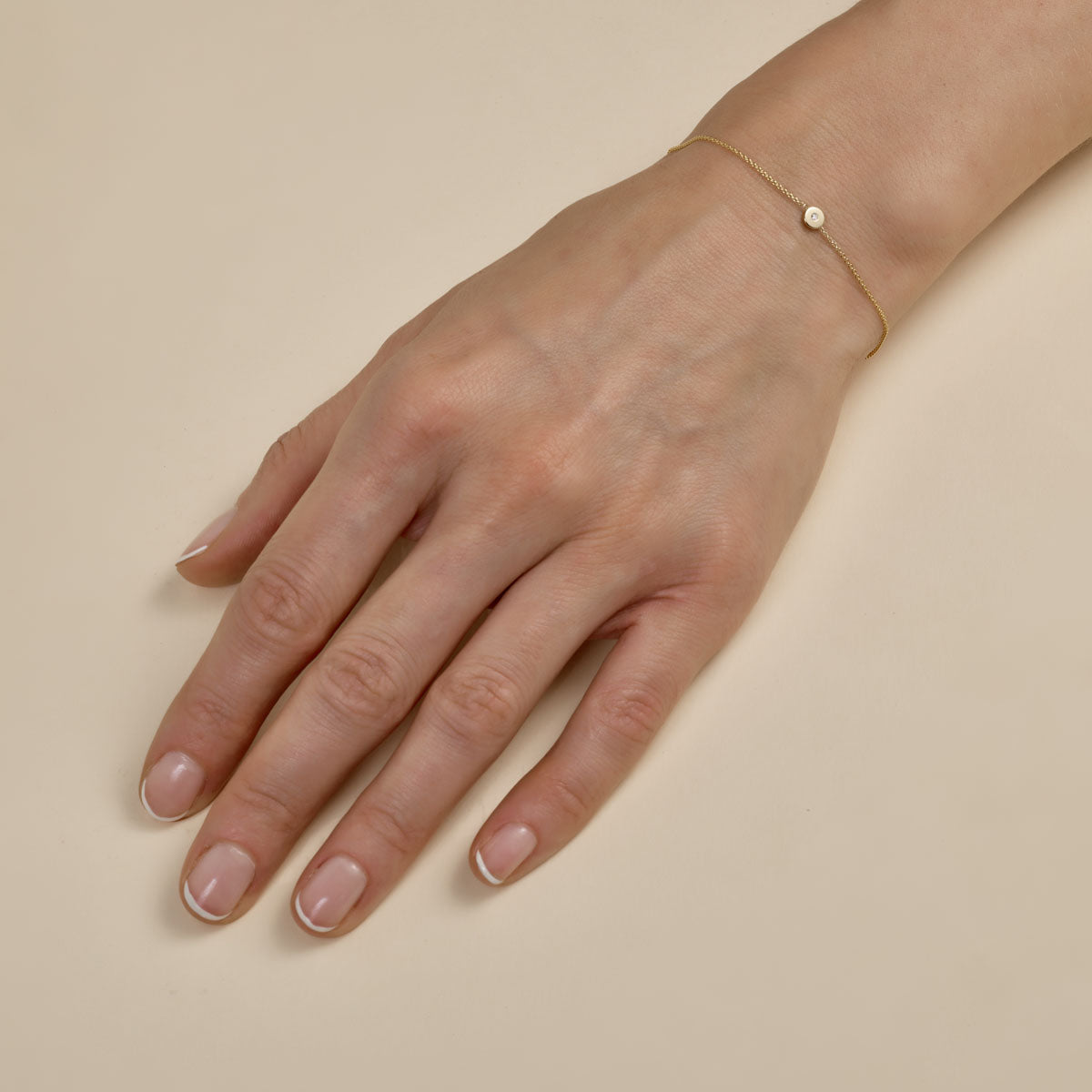 Dainty gold sun disc bracelet - delicate celestial charm on woman's wrist