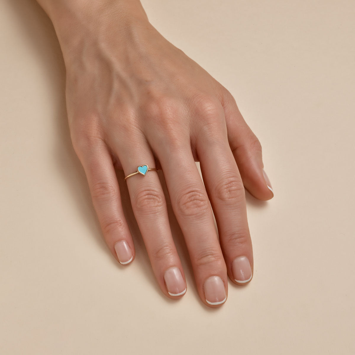 turquoise heart gold ring on womans finger