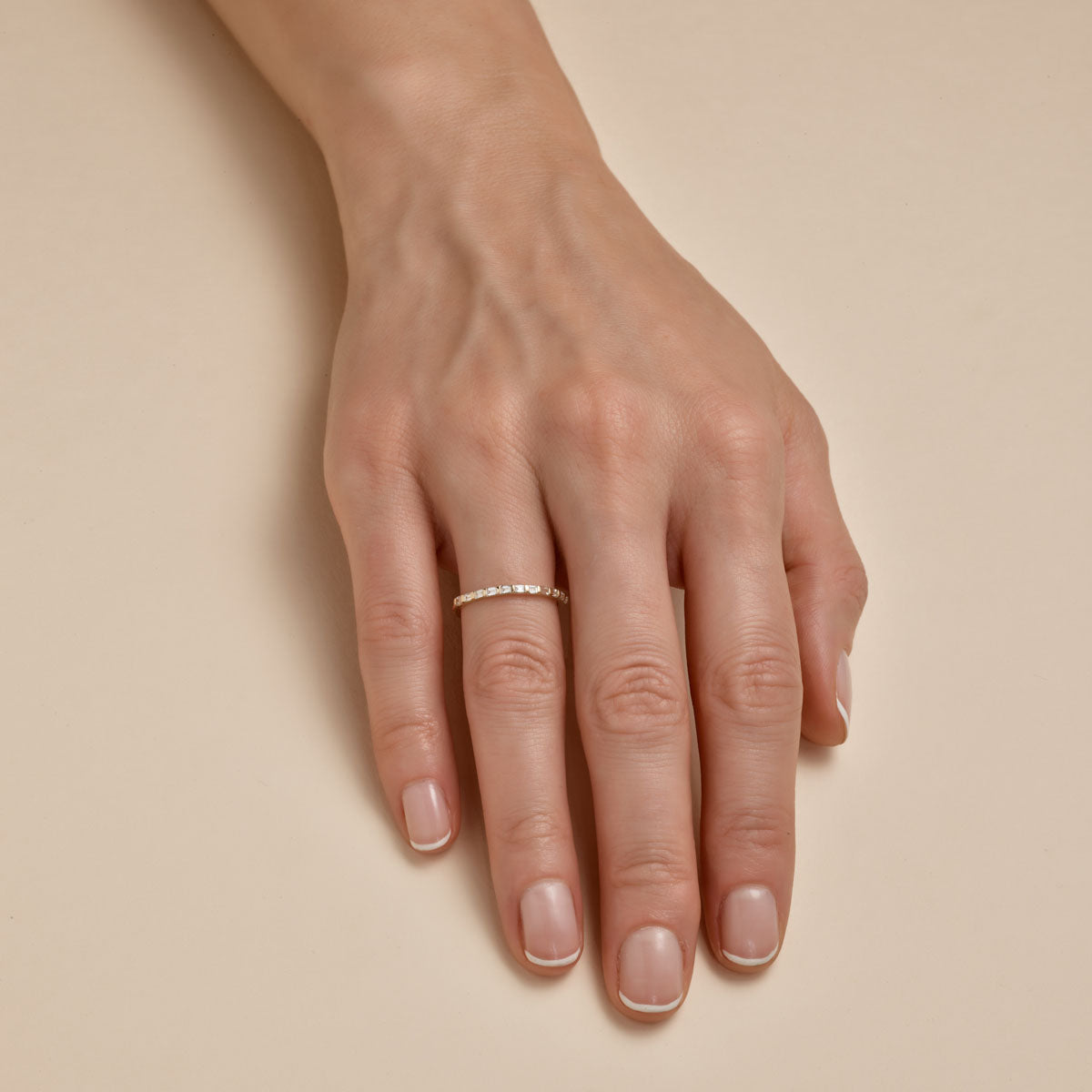 white Baguette diamond band ring on womans finger