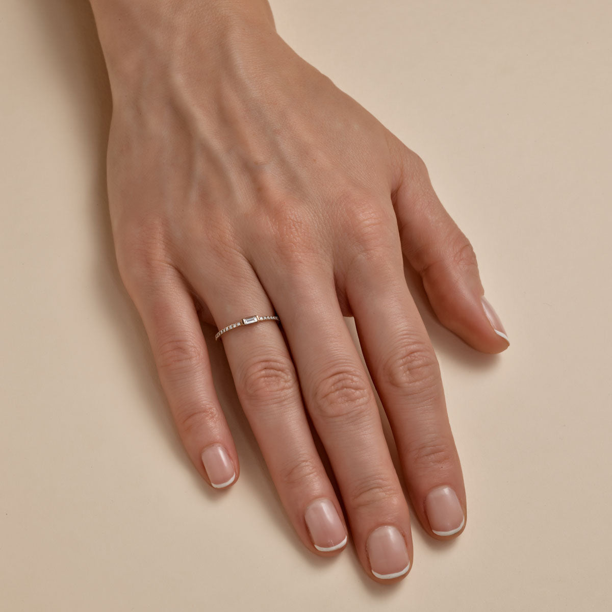 white baguette diamond ring on womans finger